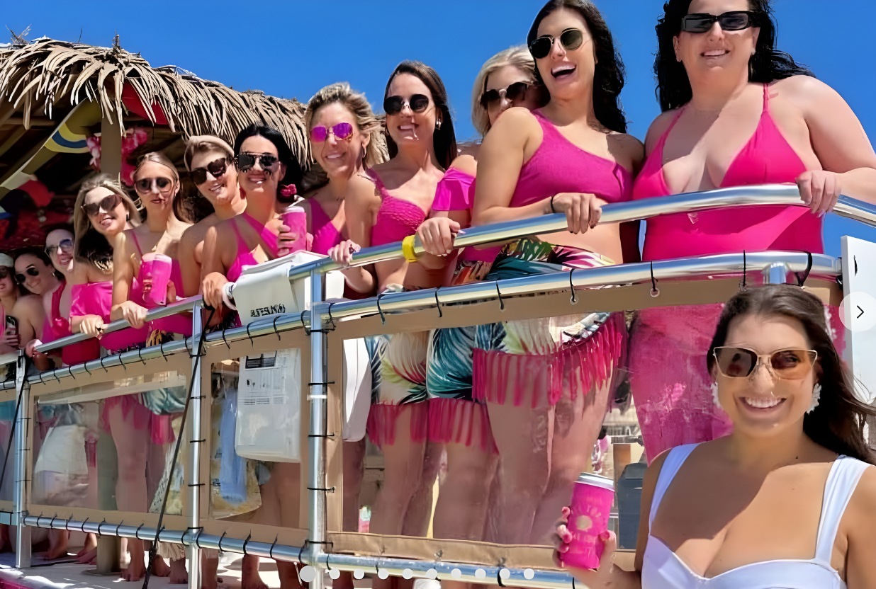 Girls lined up in pink bathing suits on a pontoon boat in Destin Florida